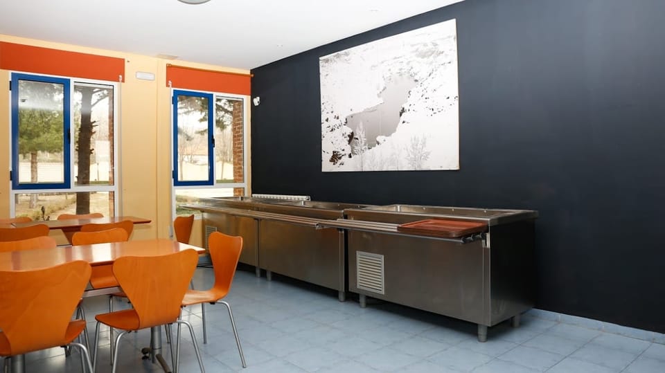 Office del comedor, con encimera de acero inoxidable junto a las mesas