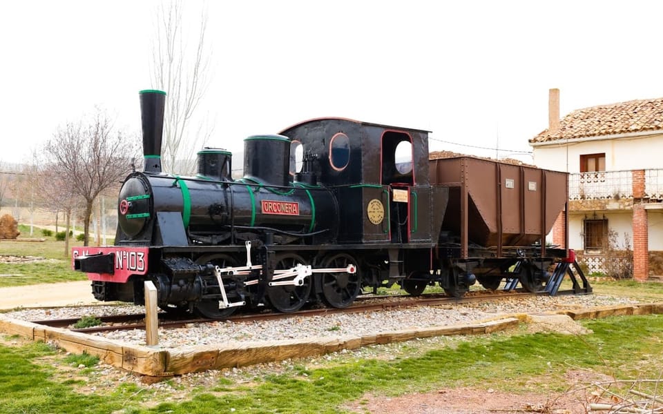 Locomotora de vapor de la compañía minera, conservada sobre un tramo de vía a la entrada del pueblo